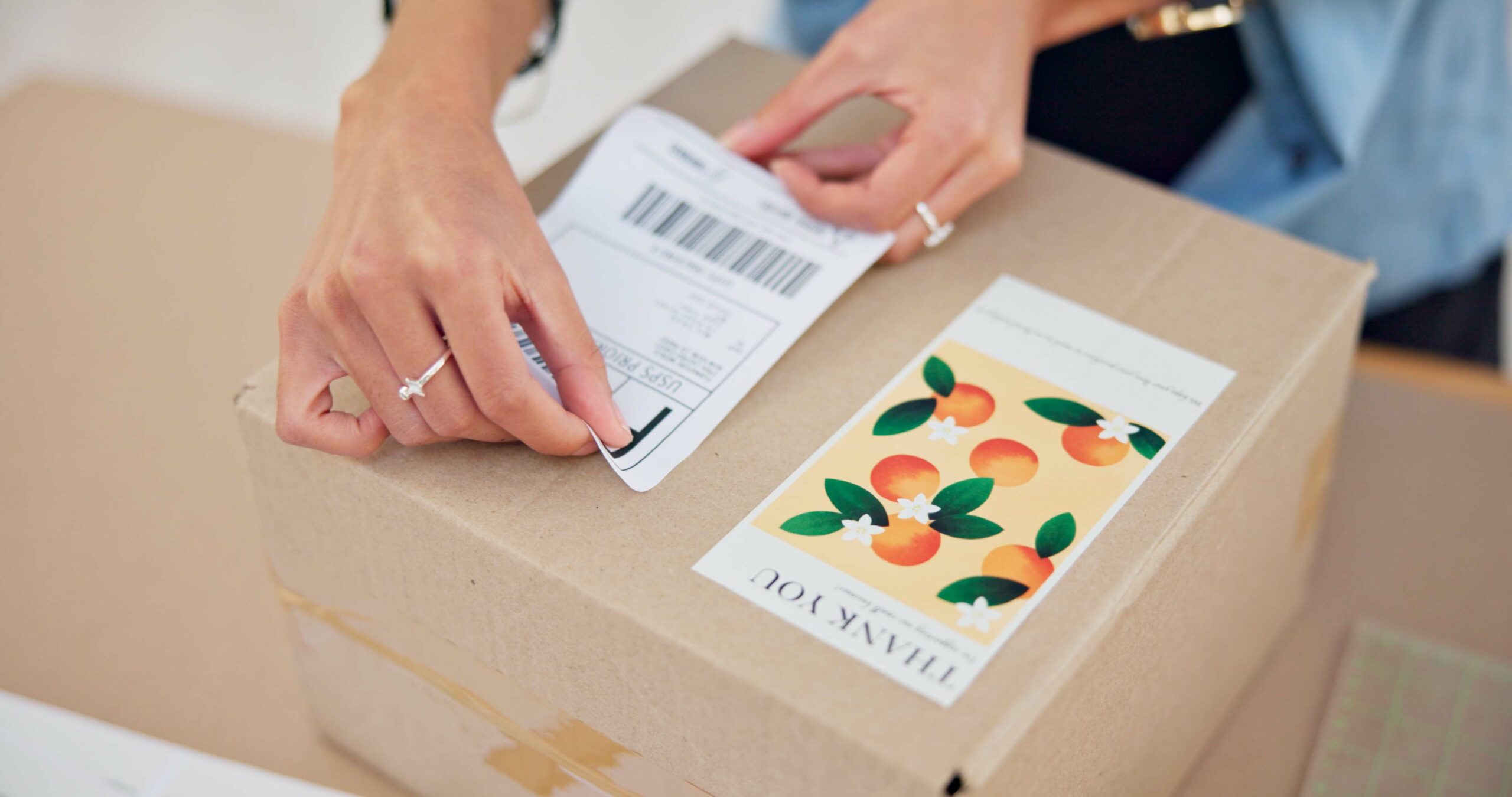 Online order, delivery label and woman hand with small business sticker for cardboard box. Stock, s.