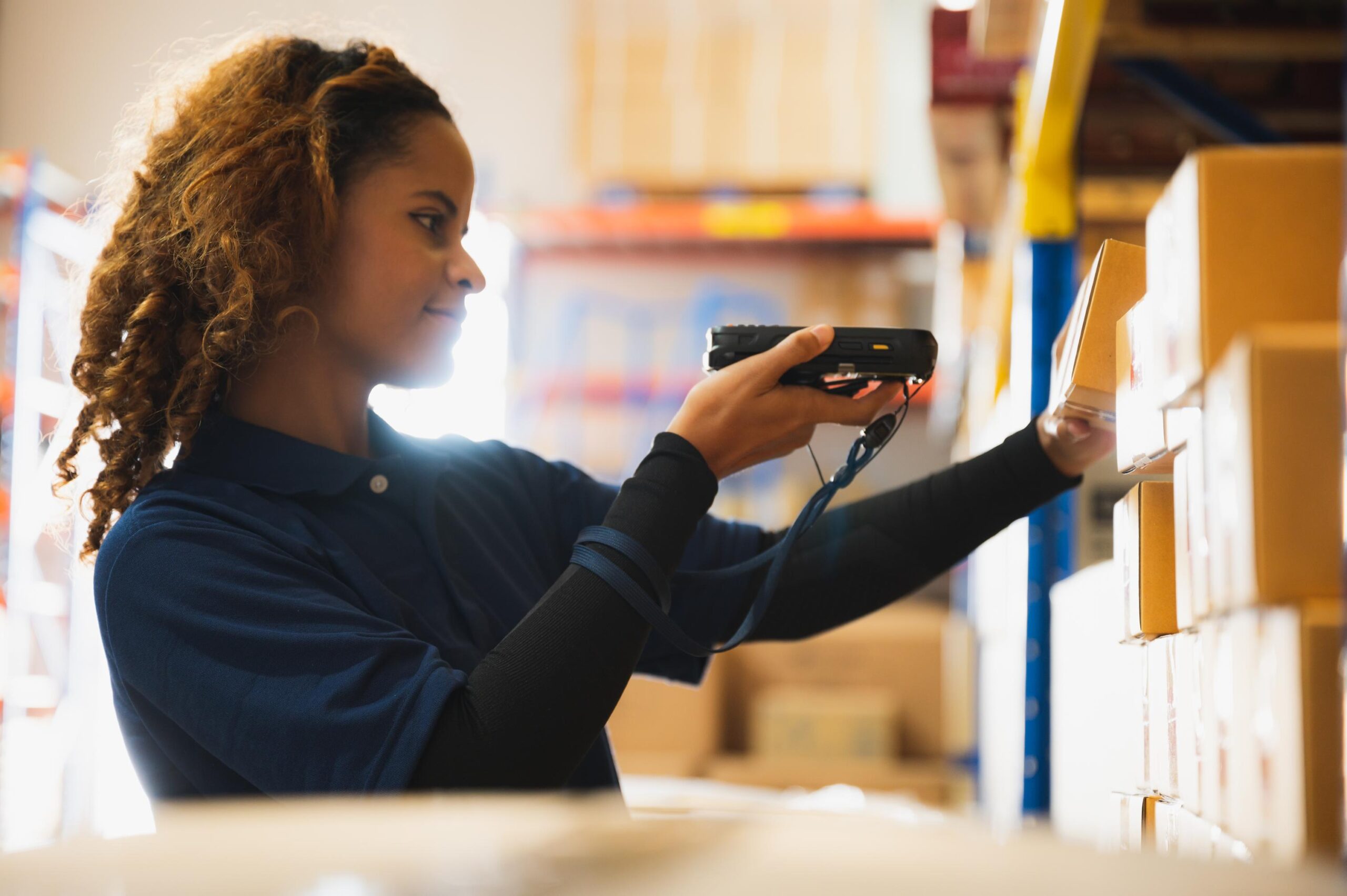 Portrait of African American worker in warehouse, International export business concept, occupation industrial in factory storage, warehouse worker using bar code scanner to analyze newly arrived good
