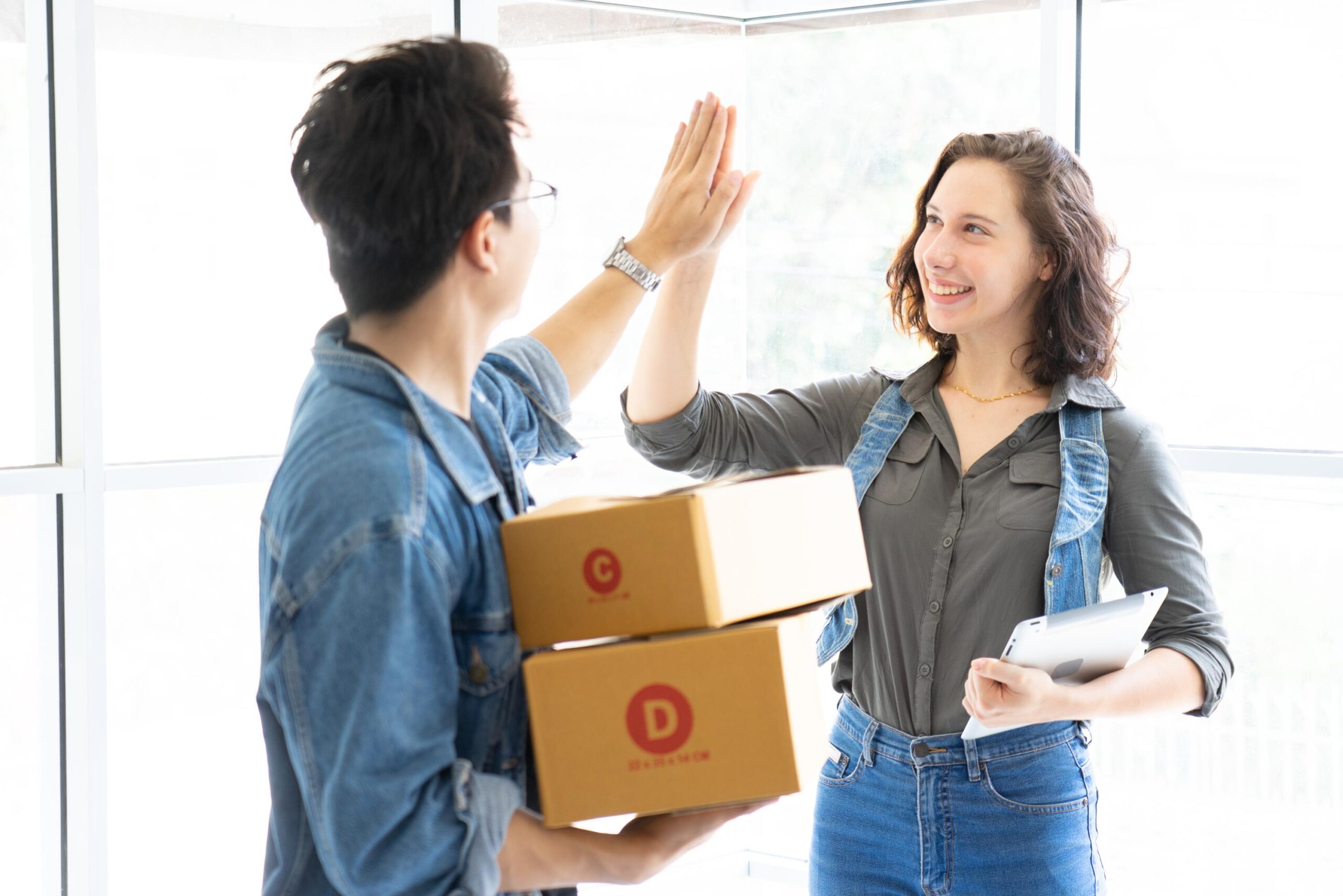Worker In Warehouse Checking Boxes Using Digital Tablet.Start up small business entrepreneur SME or freelance man and woman working  at home concept, Young Asian small business owner,online marketing.
